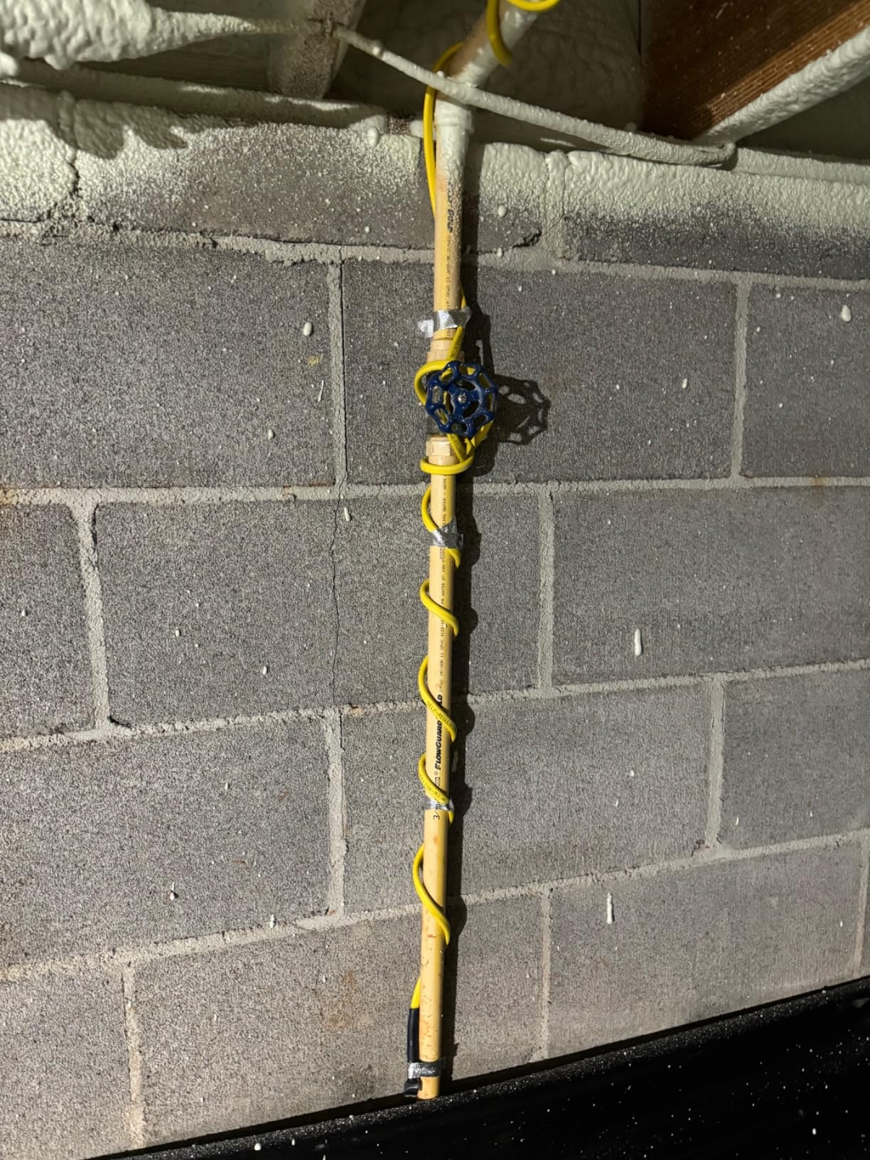 YeloDeer pipe heating cable wrapped around a water pipe along a wall, providing freeze protection during winter.